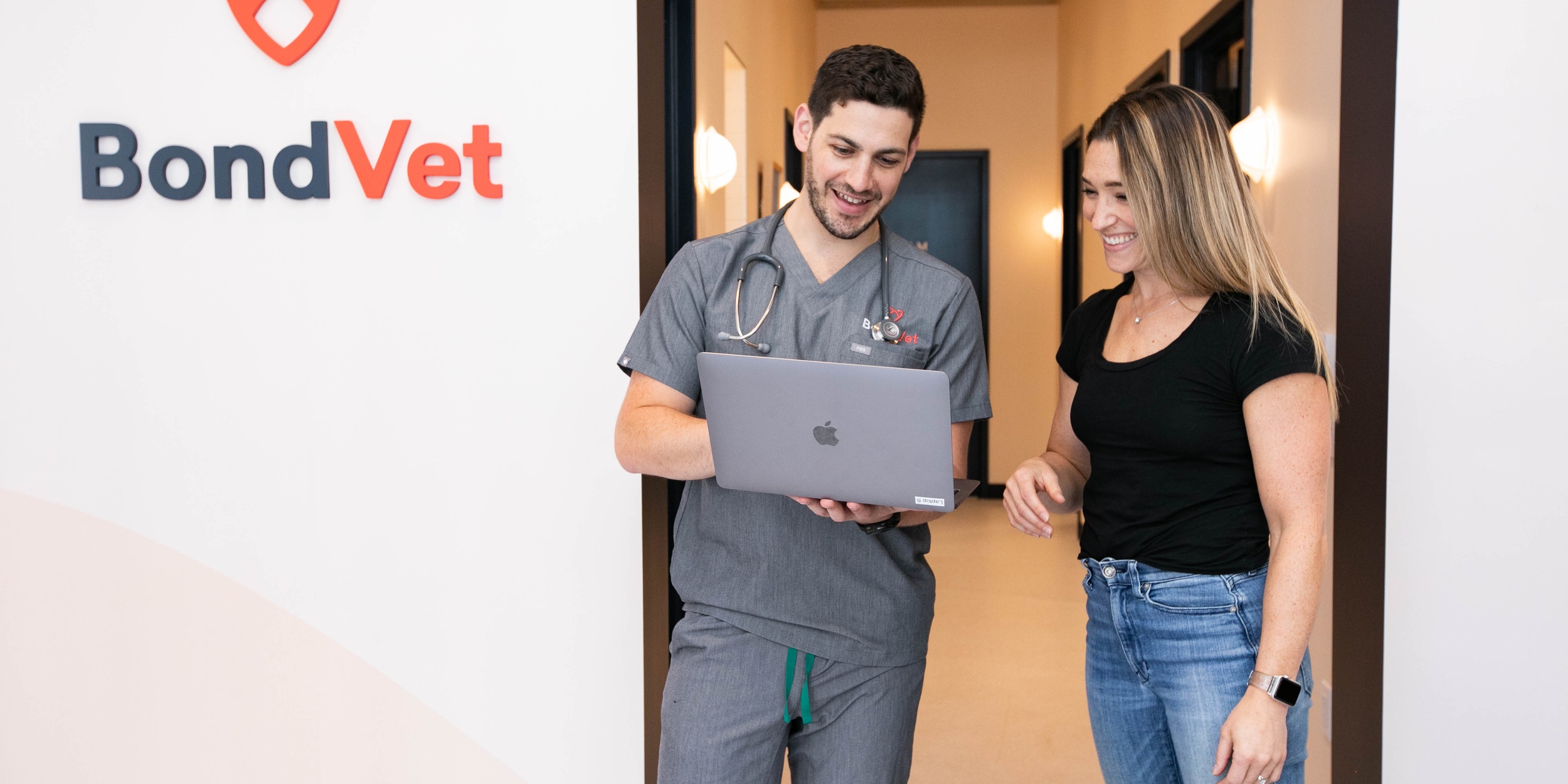 Veterinarian discussing treatment plans with a client and their dog Bond Vet - West Midtown