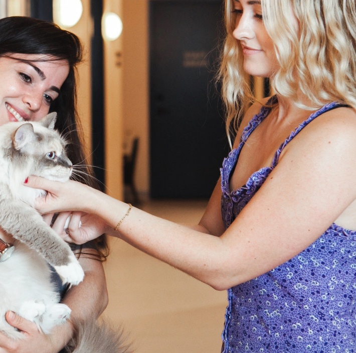 A woman is petting a cat.